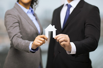 Image showing businessman and businesswoman holding white house