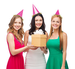 Image showing three smiling women in blue hats with gift box