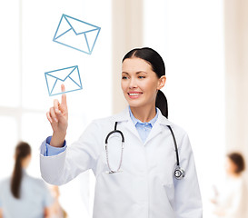 Image showing smiling female doctor pointing to envelope