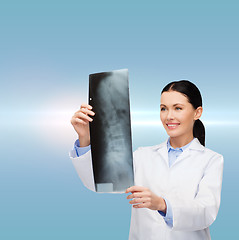 Image showing smiling female doctor looking at x-ray