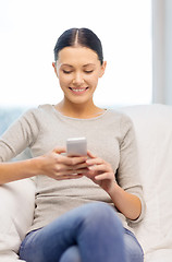 Image showing smiling woman with smartphone at home