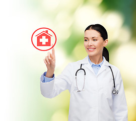 Image showing smiling female doctor pointing to hospital sign