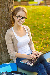 Image showing smiling teenager in eyeglasses with laptop