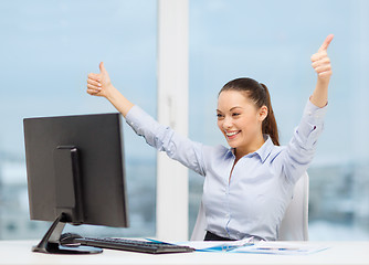 Image showing woman with computer, papers showing thumbs up