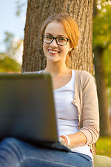 Image showing smiling teenager in eyeglasses with laptop