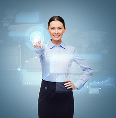 Image showing smiling businesswoman pointing finger to button