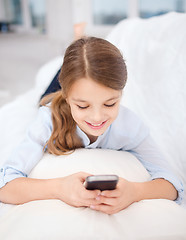 Image showing smiling girl with smartphone at home