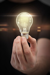 Image showing close up of man hand holding light bulb