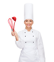 Image showing smiling female chef with cooking equipment