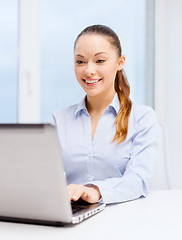 Image showing smiling businesswoman with laptop in office