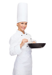 Image showing smiling female chef with pan and spoon