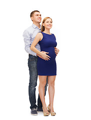 Image showing happy young family expecting child looking up