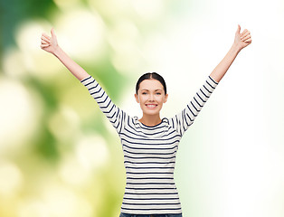 Image showing smiling girl in casual clother showing thumbs up