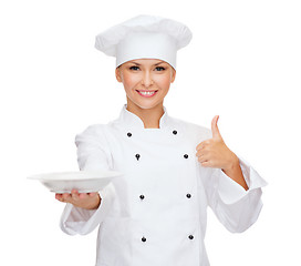Image showing female chef with empty plate showing thumbs up