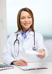 Image showing smiling doctor with laptop computer and clipboard
