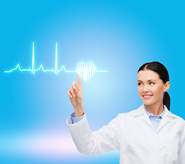 Image showing smiling female doctor pointing to cardiogram