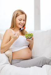 Image showing happy pregnant woman eating salad