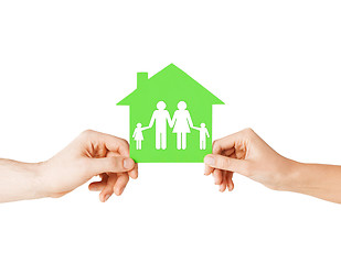 Image showing hands holding green house with family