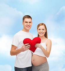 Image showing happy young family expecting child with big heart