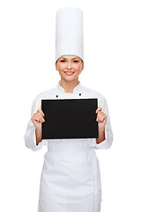 Image showing smiling female chef with black blank paper