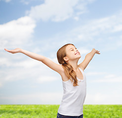 Image showing smiling teenage girl with raised hands