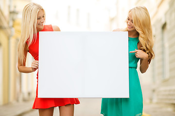 Image showing two happy blonde women with blank white board