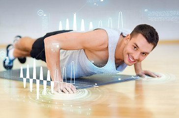 Image showing smiling man doing push-ups in the gym