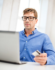 Image showing man with laptop and credit card at home