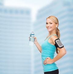 Image showing sporty woman running with smartphone and earphones