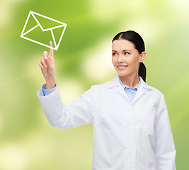 Image showing smiling female doctor pointing to envelope