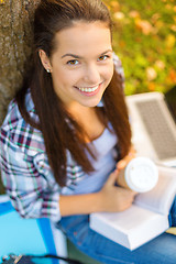 Image showing teenager reading book with take away coffee