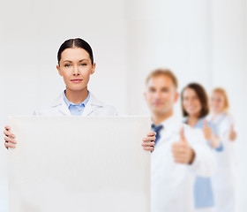 Image showing calm female doctor with white blank board