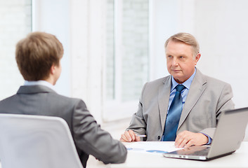 Image showing older man and young man having meeting in office