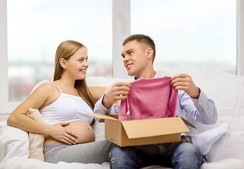 Image showing happy family expecting child opening parcel box