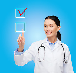 Image showing smiling female doctor pointing to checkbox