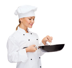 Image showing smiling female chef with pan and spoon