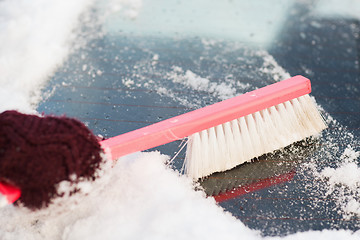 Image showing woman cleaning snow from car back window