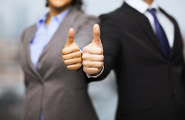 Image showing businessman and businesswoman showing thumbs up