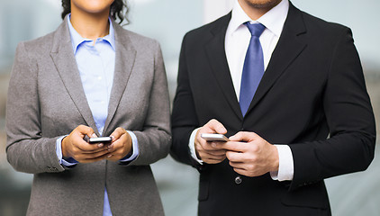 Image showing businessman and businesswoman with smartphones