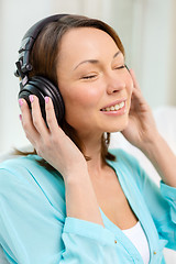 Image showing smiling woman with headphones at home