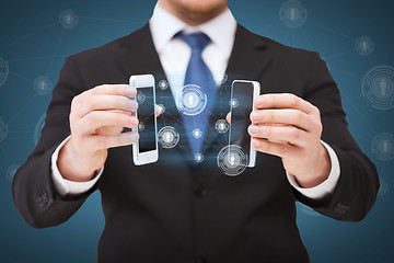 Image showing businessman showing smartphones with blank screens