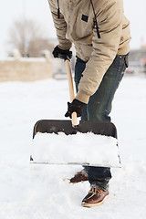 Image showing closeup of man shoveling snow from driveway