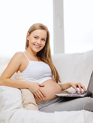 Image showing smiling pregnant woman with laptop computer