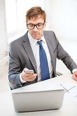 Image showing businessman working with laptop and smartphone