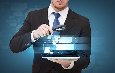 Image showing businessman hand holding magnifier over tablet pc