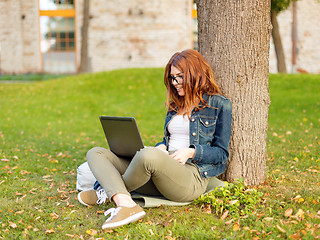 Image showing smiling teenager in eyeglasses with laptop