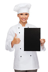 Image showing smiling female chef with black blank paper