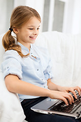 Image showing smiling girl with laptop computer at home