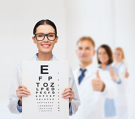 Image showing female doctor in eyeglasses with eye chart