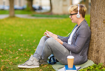 Image showing boy with headphones, tablet pc, books and coffee